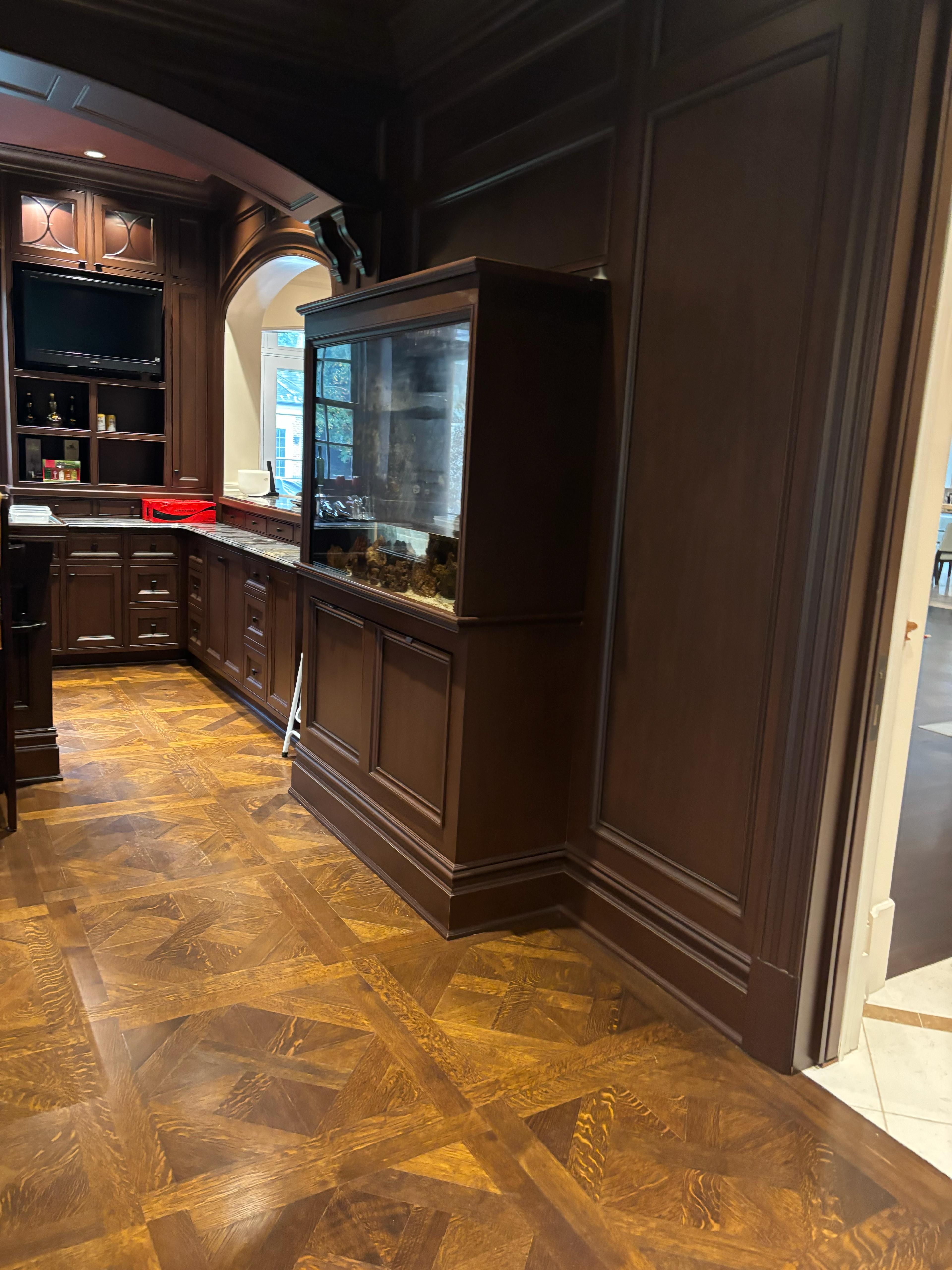 Built-in aquarium with dark wood cabinetry and parquet flooring in luxury Brooklyn home